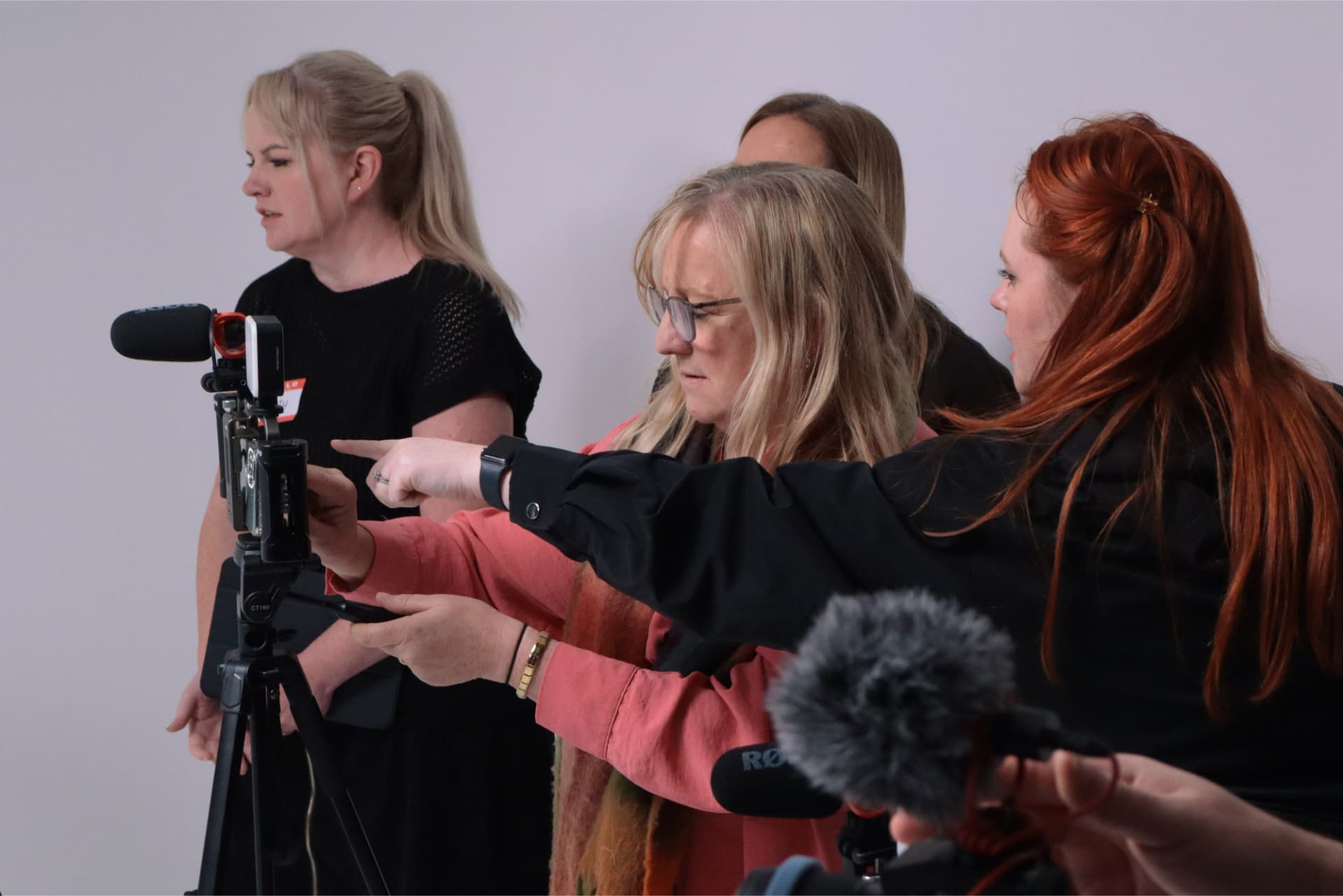 Educators operating a camera together in a workshop