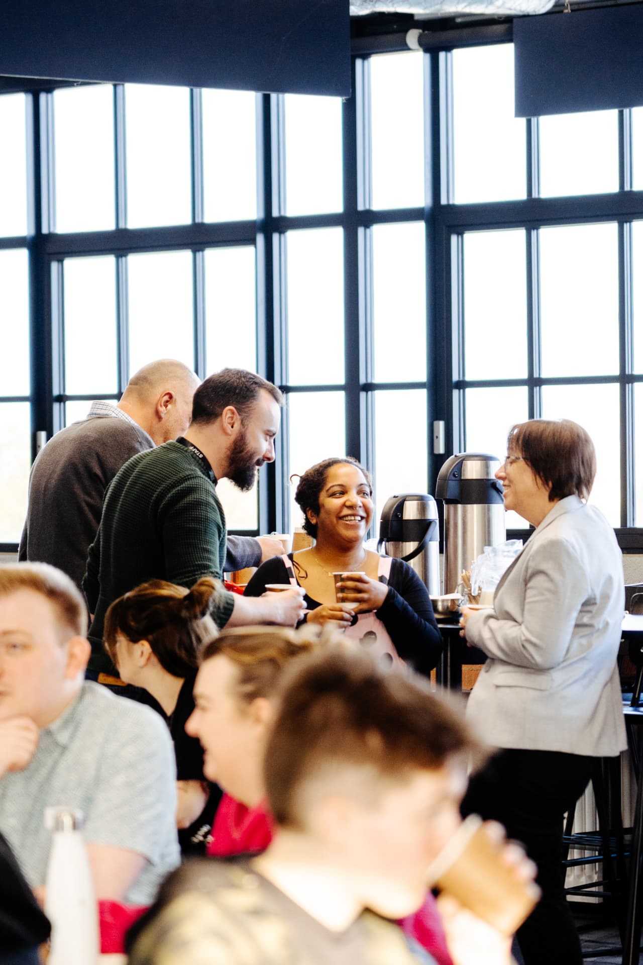 Educators talking and laughing with drinks at a Creative Educators Network event