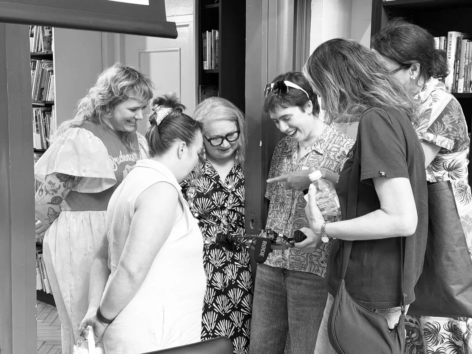 A group of educators gathered around a phone during a workshop